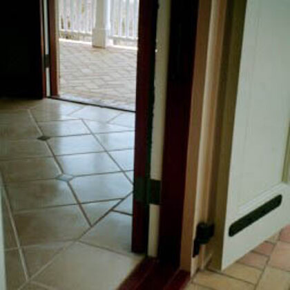 Interior 12" parchment floor tile with 3" green detail next to exterior deck with soaps