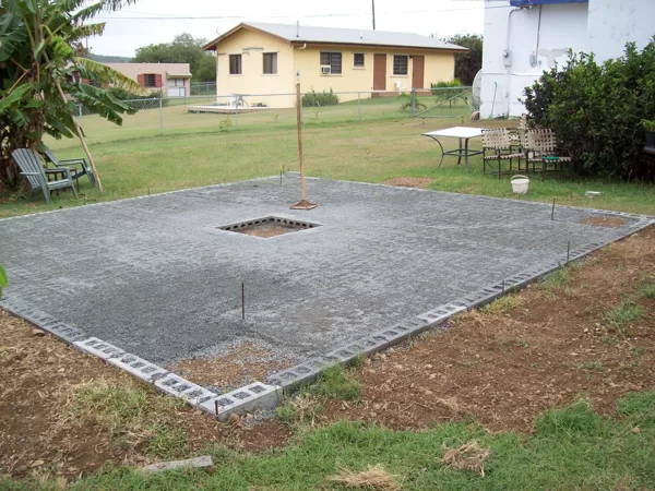 Backyard patio with planters in the corners and firepit in the middle