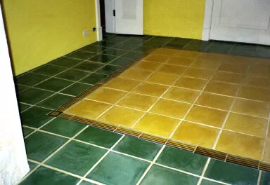 Dark green floor tile, hand painted striped 4" X 8" border around 12" yellow floor tile